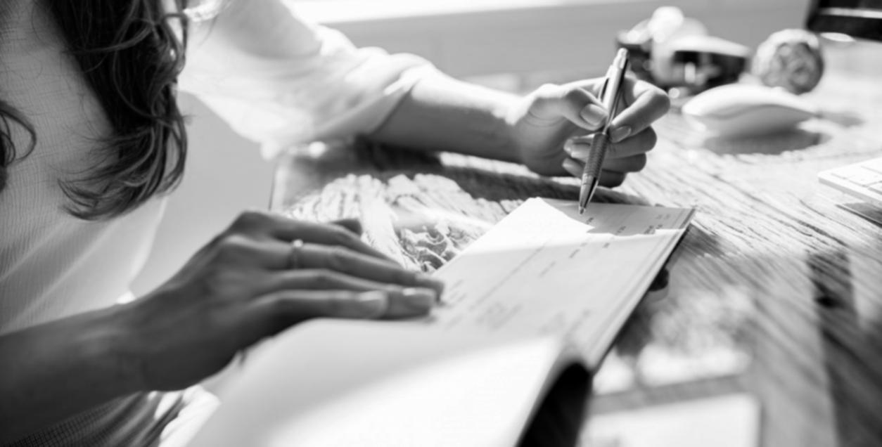 Student arbetar med finansiella beräkningar vid skrivbord med anteckningsböcker